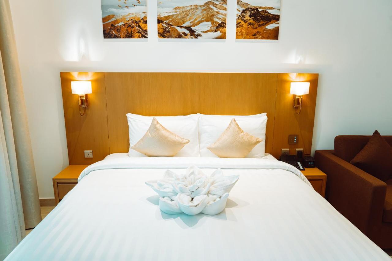 He Hotel Apartments Dubai Room photo A bed with a bedsheet